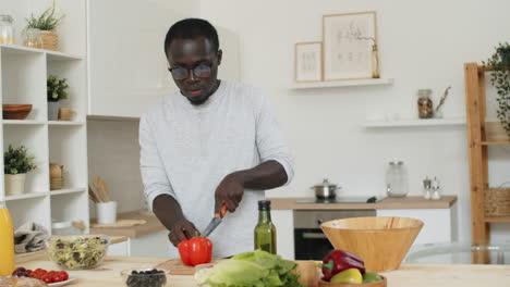 Hombre-Afroamericano-Preparando-Ensalada-De-Verduras-En-La-Cocina
